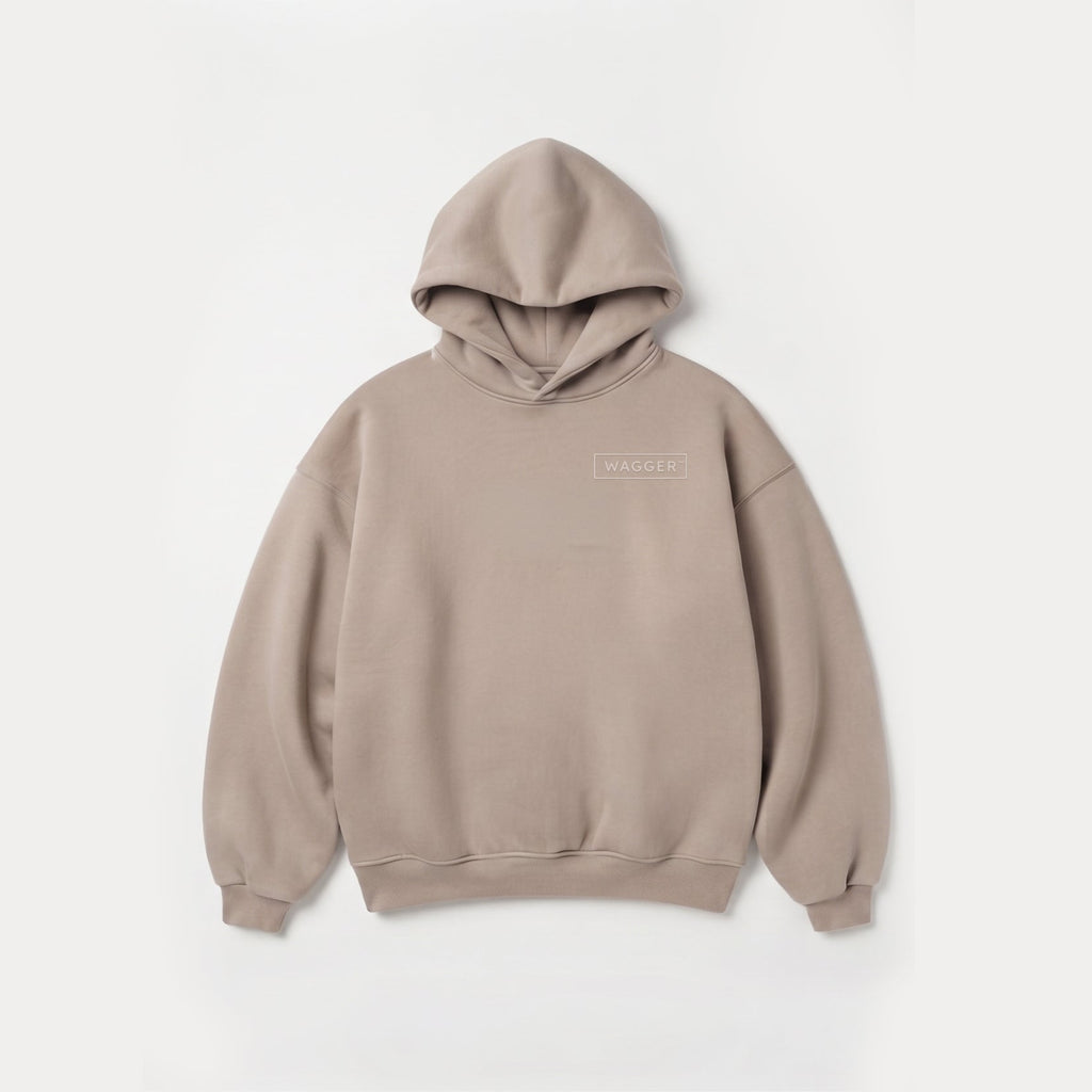 A light taupe-beige pullover hoodie with a small rectangular logo patch on the left chest, displayed flat against a clean white background.